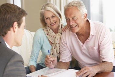 Professional couple reviewing documents with advisor, representing jumbo loans for high-value homes in Long Island and NYC